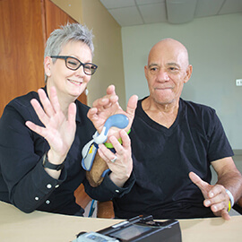 Rehabilitation Therapist works with patient to complete hand exercises.