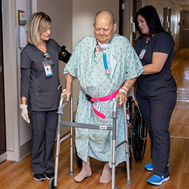 Patient on ventilator walks using a walker.